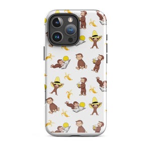 Op de afbeelding: Een witte telefoonhoes met een herhaald patroon van een bruine aap in verschillende poses, bananen en gele hoeden. De hoes heeft een uitsparing voor een drievoudige cameralens en zwarte zijaccenten.