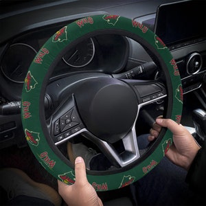 Può includere: Coprivolante verde e nero con il logo dei Minnesota Wild e la parola "WILD" ripetuta attorno al coprivolante.