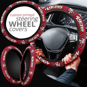 May include: Red and gold steering wheel cover with the text "49ERS" repeated around the cover. The text "custom printed steering wheel covers" is displayed on the cover.