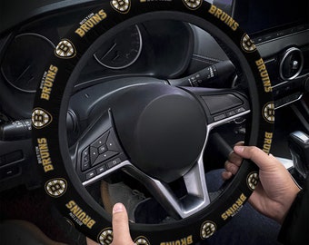 May include: Black steering wheel cover with a gold and black Boston Bruins logo repeated around the cover.