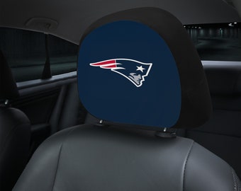 Pode incluir: Um apoio de cabeça para assento de carro azul e preto com o logotipo dos New England Patriots bordado.