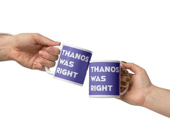 Könnte beinhalten: Zwei weiße Keramikbecher mit dem Text "THANOS WAS RIGHT" in weißen Buchstaben auf lila Hintergrund. Die Becher werden von zwei Händen vor weißem Hintergrund gehalten.