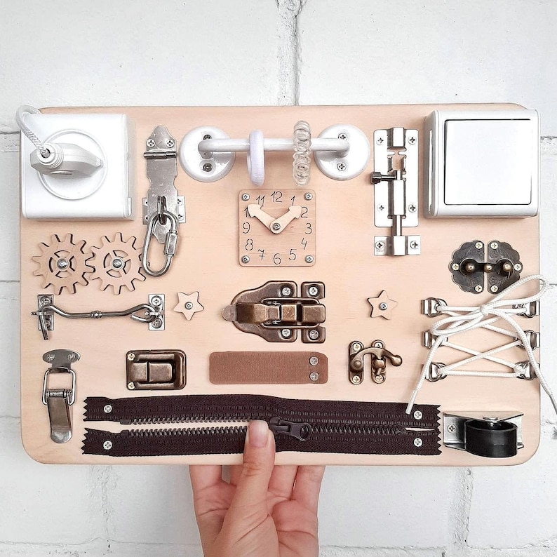 busy board with many sensory elements such as switches, a socket, various types of locks, lacing, clock, rubber bands.