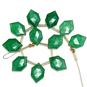 May include: A strand of green gemstone beads with faceted surfaces. The beads are strung on a wire with gold-colored spacers.