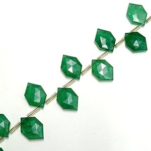 May include: A strand of green gemstone beads with faceted edges. The beads are strung on gold-colored wire.