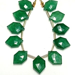 May include: A strand of green gemstone beads with faceted, diamond-shaped beads. The beads are strung on gold-toned wire.