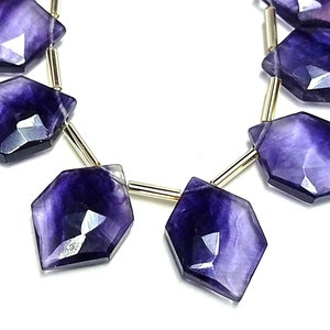 Puede incluir: Hilo de cuentas facetadas de fluorita p&uacute;rpura. Cada cuenta tiene una forma geom&eacute;trica &uacute;nica con una superficie pulida y reflectante. Las cuentas est&aacute;n ensartadas en un alambre dorado, creando un hermoso contraste. Ideal para la fabricaci&oacute;n de joyas.
