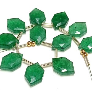 May include: A strand of green gemstone beads with gold spacers. The beads are faceted and have a slightly irregular shape. The strand is strung on a wire.