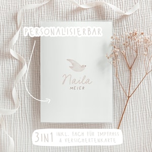 May include: A personalized baby card with the name "Naila Meier" and a small bird illustration. The card is white with text in a soft brown color. The words "PERSONALISIERBAR" and "3IN1 INKL. FACH FÜR IMPFPASS & VERSICHERTENKARTE" are also visible.