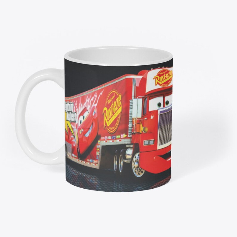 May include: A white ceramic mug with a red and black image of a red semi-truck with the words "Rust-eze" and "Rust-eze" on the side. The truck is pulling a trailer with a red race car on the side. The race car has the words "Rust-eze" and "Lightning McQueen" on the side.