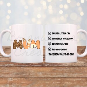 May include: White ceramic mug with a brown and orange design that says "MUM" on one side. The other side has a checklist with the text "I have a little cry, then I pick myself up, dust myself off, and keep going. The show must go on!"