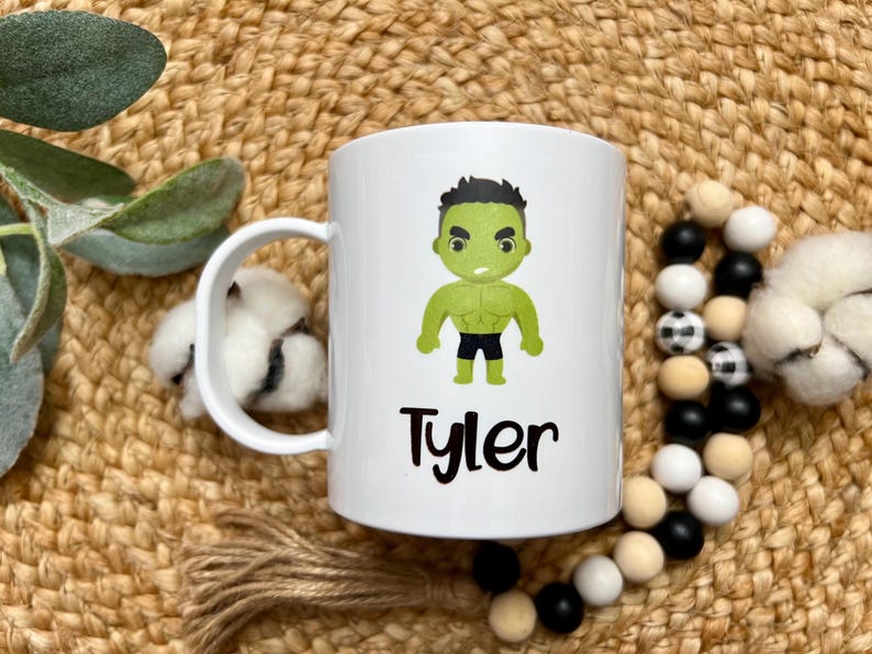 May include: White ceramic mug with a green cartoon character of the Hulk and the name "Tyler" printed on it.
