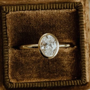 Oval Moissanite Engagement Ring: Bezel Set Sterling Silver Solitaire