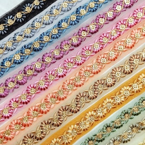 May include: A collection of 12 different trims featuring a delicate floral design with gold accents. The trims are made of a sheer fabric and are perfect for adding a touch of elegance to any project.