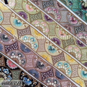 May include: Six different trims of embroidered fabric with a geometric pattern of flowers and sequins. The trims are in various colors, including teal, gray, beige, and purple. The trims are labeled with numbers 1 through 6.