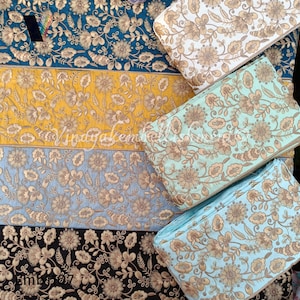 May include: Four rolls of gold embroidered trim with floral patterns on different colored fabric backgrounds. The trims are teal, yellow, light blue, and black.