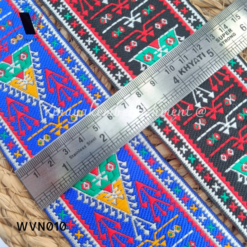 May include: Two colorful patterned fabric trims with a ruler measuring 15 inches. The trim is red, blue, green, yellow, and white. The trim is woven with a geometric pattern.