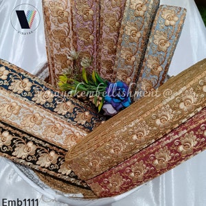 May include: Assortment of gold embroidered trim with floral designs. The trim is in various colors including black, white, beige, light blue, pink, and burgundy.