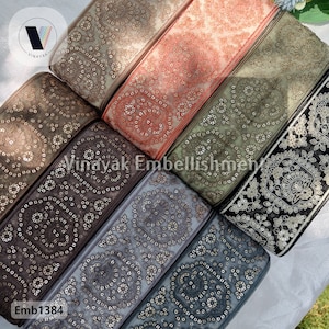 May include: Assortment of six embroidered trim ribbons with various patterns and colors, including brown, gray, green, and orange. The trim features a repeating circular design with gold sequins. The text "Emb1384" is visible in the bottom left corner.