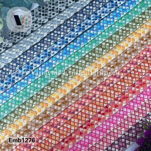 May include: A variety of colorful embroidered trim with a geometric diamond pattern. The trim is arranged in a rainbow pattern, with each color separated by a white line. The trim is labeled "Emb1276".
