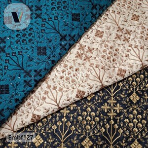 Pode incluir: Três amostras de tecido com padrões florais bordados. A amostra superior é azul turquesa com bordado preto, a amostra do meio é bege com bordado castanho e a amostra inferior é preta com bordado dourado. O texto "Embf127" é visível no canto inferior esquerdo.