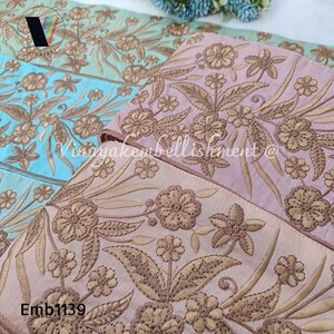 May include: A close-up of two embroidered trim pieces. The trim is a light pink color with a floral design in a brown color. The text "Emb1139" is visible in the bottom left corner of the image.