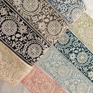 Könnte beinhalten: Fünf verschiedene Borten aus besticktem Stoff mit Blumenmustern. Die Borten sind in verschiedenen Farben, darunter beige, schwarz, blaugrün, hellblau und rosa.