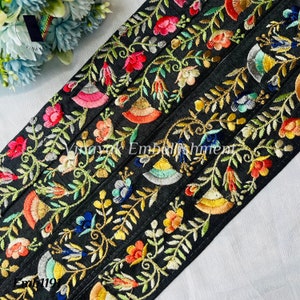 May include: Black embroidered trim with colorful floral designs. The trim is made of silk and has a satin finish. The trim is approximately 1.5 inches wide.