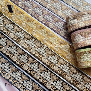 May include: Assortment of embroidered trim in various colors, including gold, purple, green, and black. The trim features a floral design with white beads.