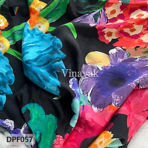 May include: Black fabric with a colourful floral design. The pattern includes large flowers in blue, purple, orange, and pink, set against a black backdrop. The fabric has the text "Vinayak" and "DPF057".