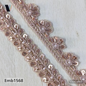 Könnte beinhalten: Zwei Streifen dekorativer Besatz mit floralem und perlenbesetztem Design. Der Besatz ist hellroségoldfarben mit kleinen, runden, weißen Perlen und Pailletten. Der Besatz hat einen gewellten Rand mit blütenförmigen Akzenten. Der Text "Emb1568" ist sichtbar.