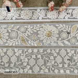 May include: Three white embroidered lace trims with gold sequins. The trims feature floral designs and are labeled #1, #2, and #3. The trim is labeled emb1363.