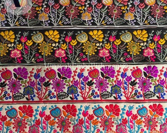 May include: Four strips of colorful embroidered trim with floral patterns. The trim is in black, white, and a variety of bright colors. The trim is perfect for adding a touch of elegance to any project.