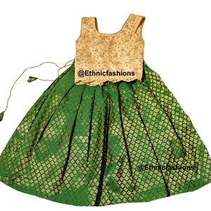 May include: A green and gold skirt and matching sleeveless top. The skirt has a gold pattern and the top has gold embroidery. The outfit is perfect for a special occasion.