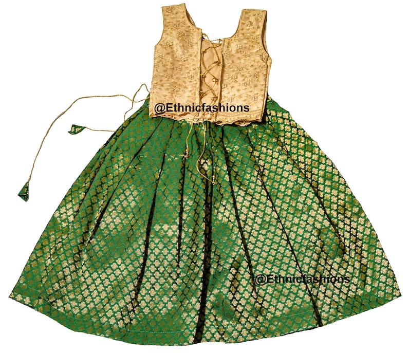 May include: A green and gold sleeveless dress with a gold embroidered bodice and a green skirt with a gold pattern. The dress has a lace-up back and a gold tassel on the skirt.