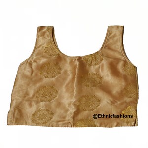 May include: A gold sleeveless top with a floral pattern. The top has a scoop neckline and is made of a satin-like fabric. The text "@Ethnicfashions" is visible at the bottom of the image.