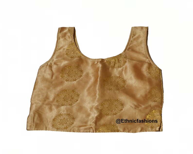 May include: A gold sleeveless top with a floral pattern. The top has a scoop neckline and is made of a satin-like fabric. The text "@Ethnicfashions" is visible at the bottom of the image.