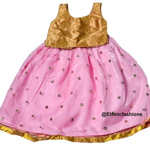 May include: A pink and gold girls' dress with a sleeveless bodice and a skirt with sequins. The skirt has a gold trim around the bottom.