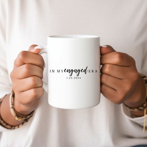 Puede incluir: Taza de cerámica blanca con texto negro que dice "In My Engaged Era 1.24.2024".