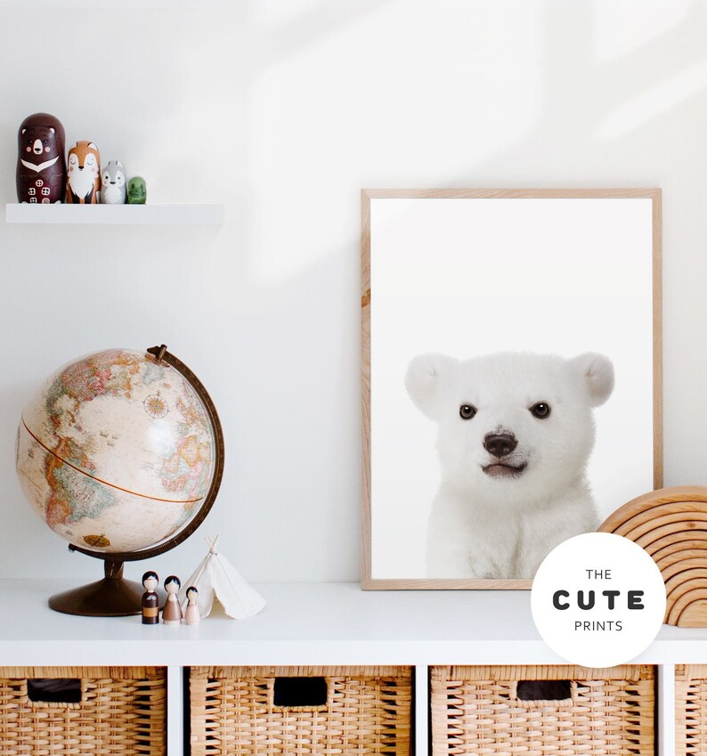 Puede incluir: Una impresi&oacute;n enmarcada de un cachorro de oso polar blanco con un marco de madera marr&oacute;n claro. La impresi&oacute;n tiene el texto "THE CUTE PRINTS" en un c&iacute;rculo blanco en la esquina inferior derecha.