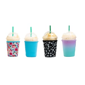 May include: Four different reusable coffee cup sleeves. The sleeves are made of neoprene and have different patterns. One sleeve has a floral pattern, one has a paw print pattern, one is solid blue, and one is a gradient of purple and blue.