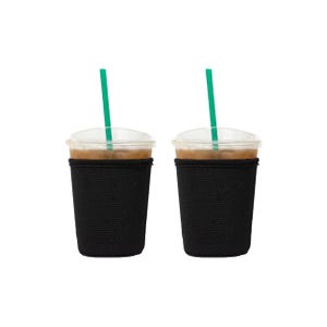 May include: Two iced coffee drinks in clear plastic cups with black sleeves and green straws.