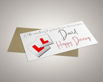 May include: A white card with the text "A little something to go towards your driving lessons David Happy Driving" and two red and white L plates. The card is placed on a brown envelope.