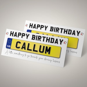 May include: Two white birthday cards with the text "HAPPY BIRTHDAY" in black. One card features a yellow GB license plate design with the name "CALLUM" and the text "A little something to go towards your driving lessons."