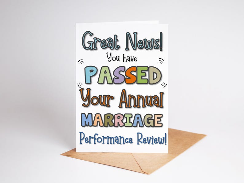 Puede incluir: Tarjeta de felicitaci&oacute;n con el texto "Great News! You have PASSED Your Annual MARRIAGE Performance Review!" en letras coloridas. La tarjeta est&aacute; sobre un sobre marr&oacute;n sobre un fondo blanco.
