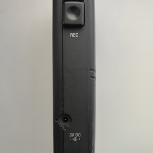 May include: A black cassette recorder with a single button labelled "REC" and a power input labelled "3V DC".