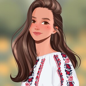 Op de afbeelding: Een vrouw met lang bruin haar draagt een witte blouse met rode en blauwe borduursels. Ze kijkt naar de zijkant en glimlacht.