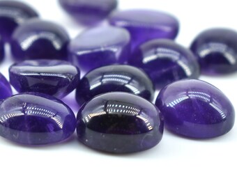 May include: A selection of smooth, oval amethyst stones in varying shades of deep purple. The gemstones have a glossy, reflective finish and are scattered against a white backdrop. These polished stones are suitable for jewellery making or crystal healing, showcasing their colour and texture.
