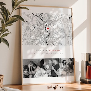 Könnte beinhalten: Gerahmter Druck mit einer schwarz-weißen Karte und einem roten Herzmarker. Unter der Karte befindet sich eine Collage von Familienfotos. Der Text "FAMILIE SCHMIDT" wird mit Koordinaten angezeigt. Der Rahmen hat eine helle Holzfarbe.