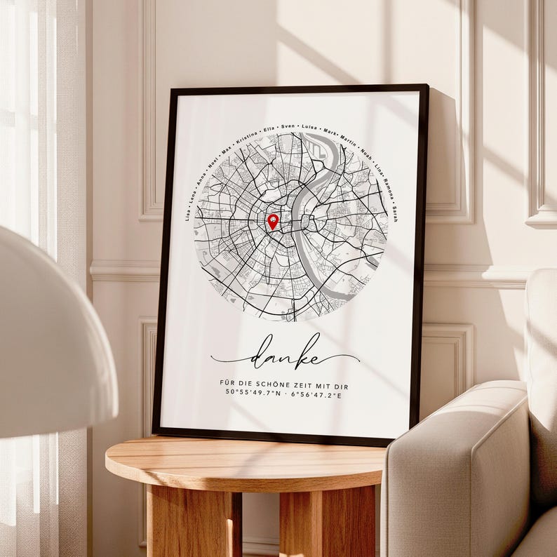 Puede incluir: Impresi&oacute;n enmarcada en blanco y negro de un mapa con un marcador rojo. La impresi&oacute;n incluye la palabra "danke" en cursiva y coordenadas. El mapa est&aacute; sobre un fondo blanco.